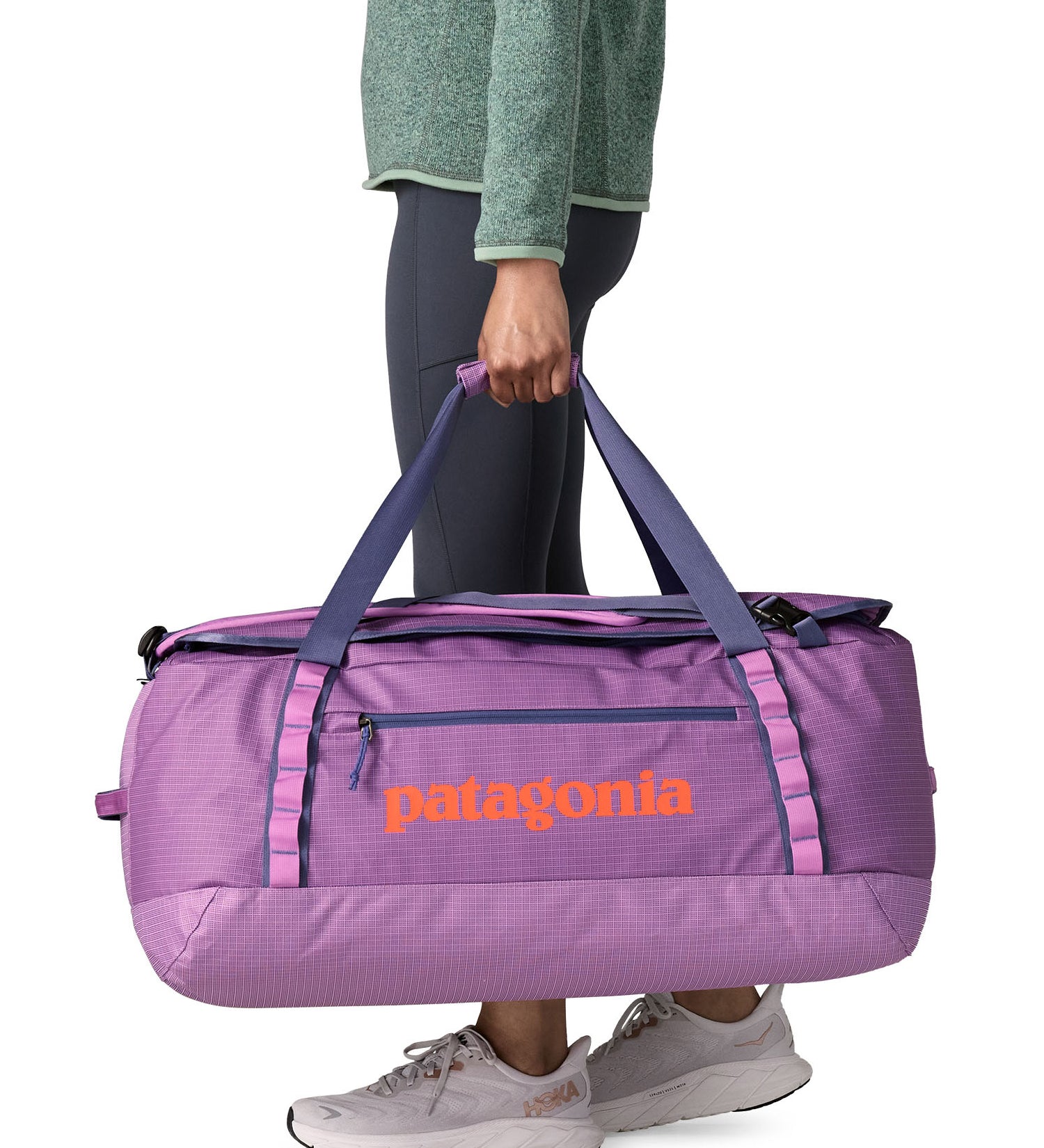A woman carrying the Patagonia black hole 70L duffel bag in brisk purple available at Babipur. 