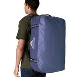 A man carrying the Patagonia black hole 70L duffel bag in current blue on his back by the shoulder straps. Backpack available at Babipur. 