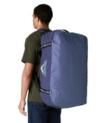 A man carrying the Patagonia black hole 70L duffel bag in current blue on his back by the shoulder straps. Backpack available at Babipur. 