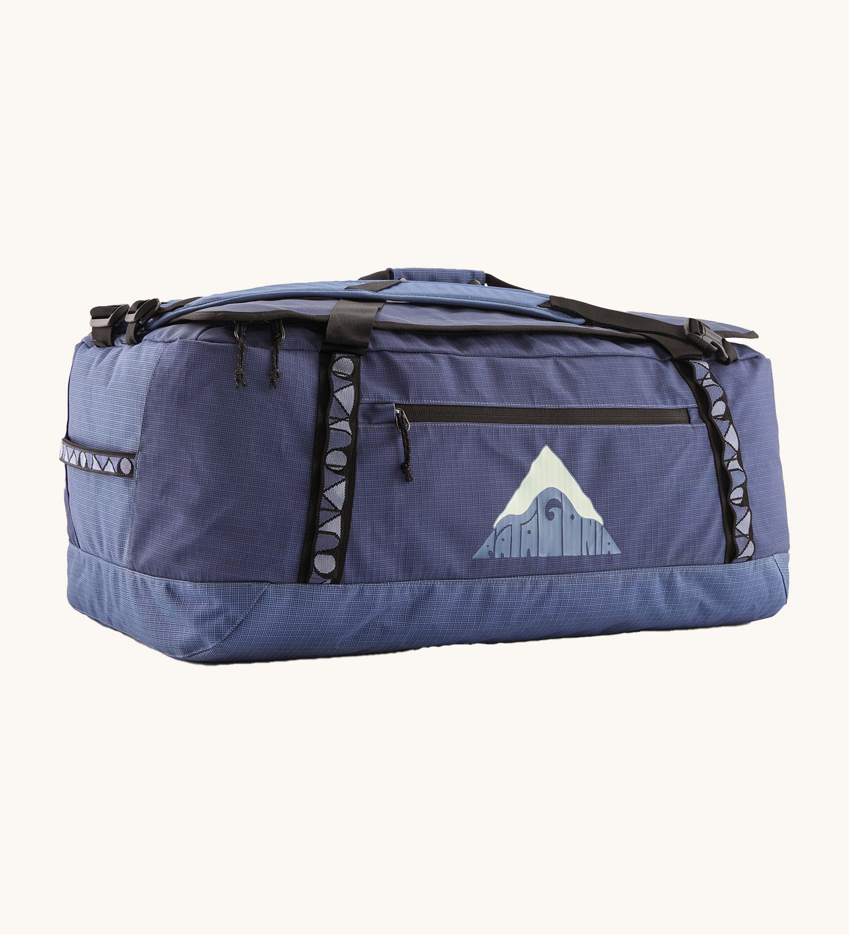 Patagonia black hole 70L duffel bag in current blue available at Babipur. A blue bag with black trim and a mountain graphic on the side. Features shoulders straps and a handle on the top for easy carrying.
