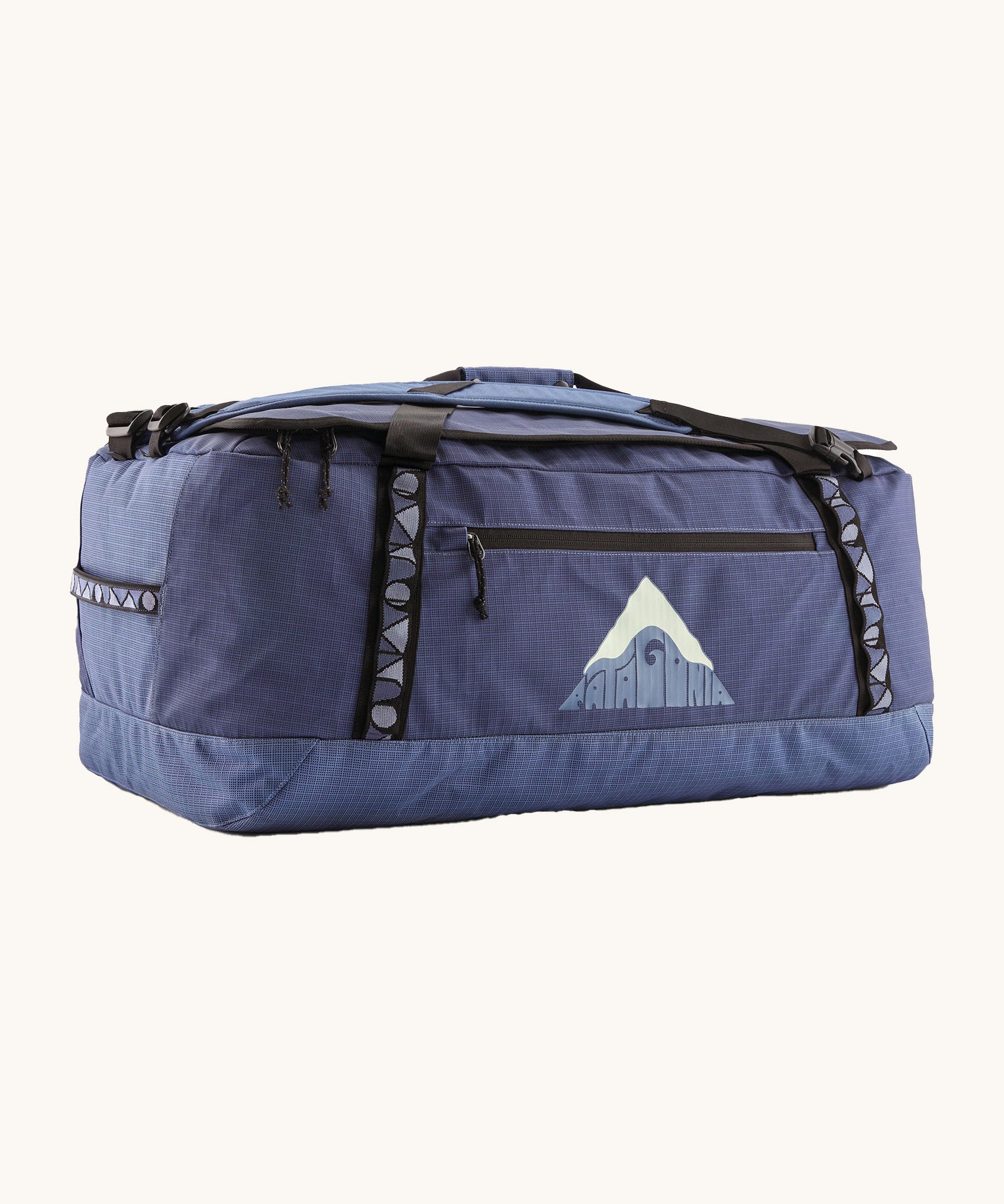 Patagonia black hole 70L duffel bag in current blue available at Babipur. A blue bag with black trim and a mountain graphic on the side. Features shoulders straps and a handle on the top for easy carrying.
