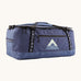 Patagonia black hole 70L duffel bag in current blue available at Babipur. A blue bag with black trim and a mountain graphic on the side. Features shoulders straps and a handle on the top for easy carrying.