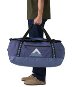 A man carrying the Patagonia black hole 70L duffel bag in current blue available at Babipur. 