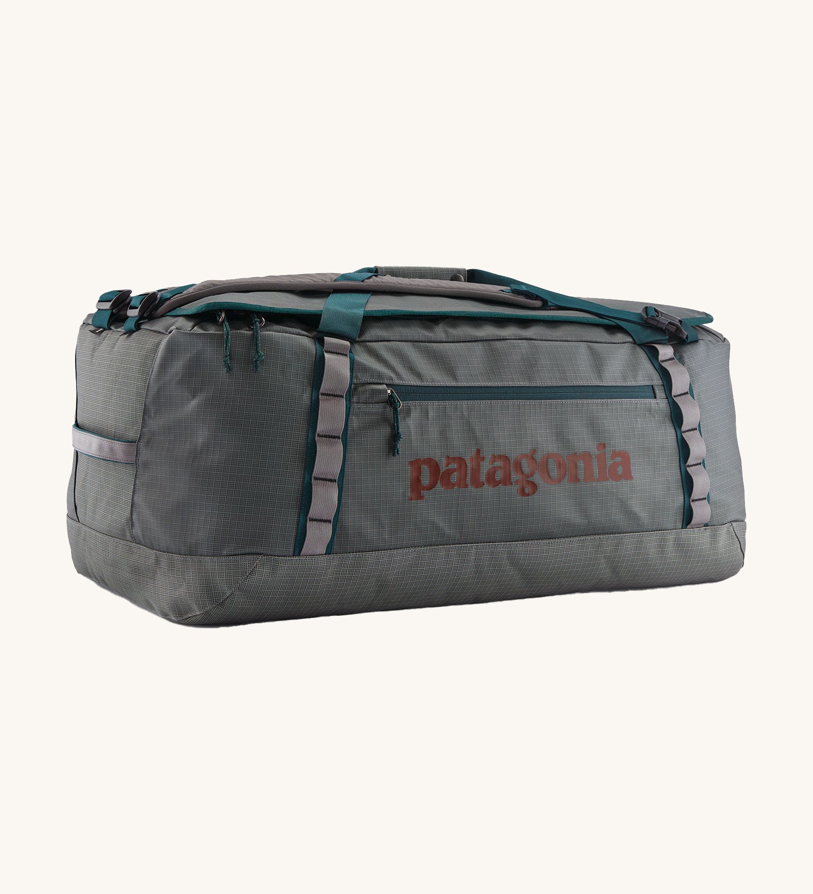 Patagonia black hole 70L duffel bag in noble grey available at Babipur. A dark grey bag with green trim and brown branding on the side. Features shoulders straps and a handle on the top for easy carrying.