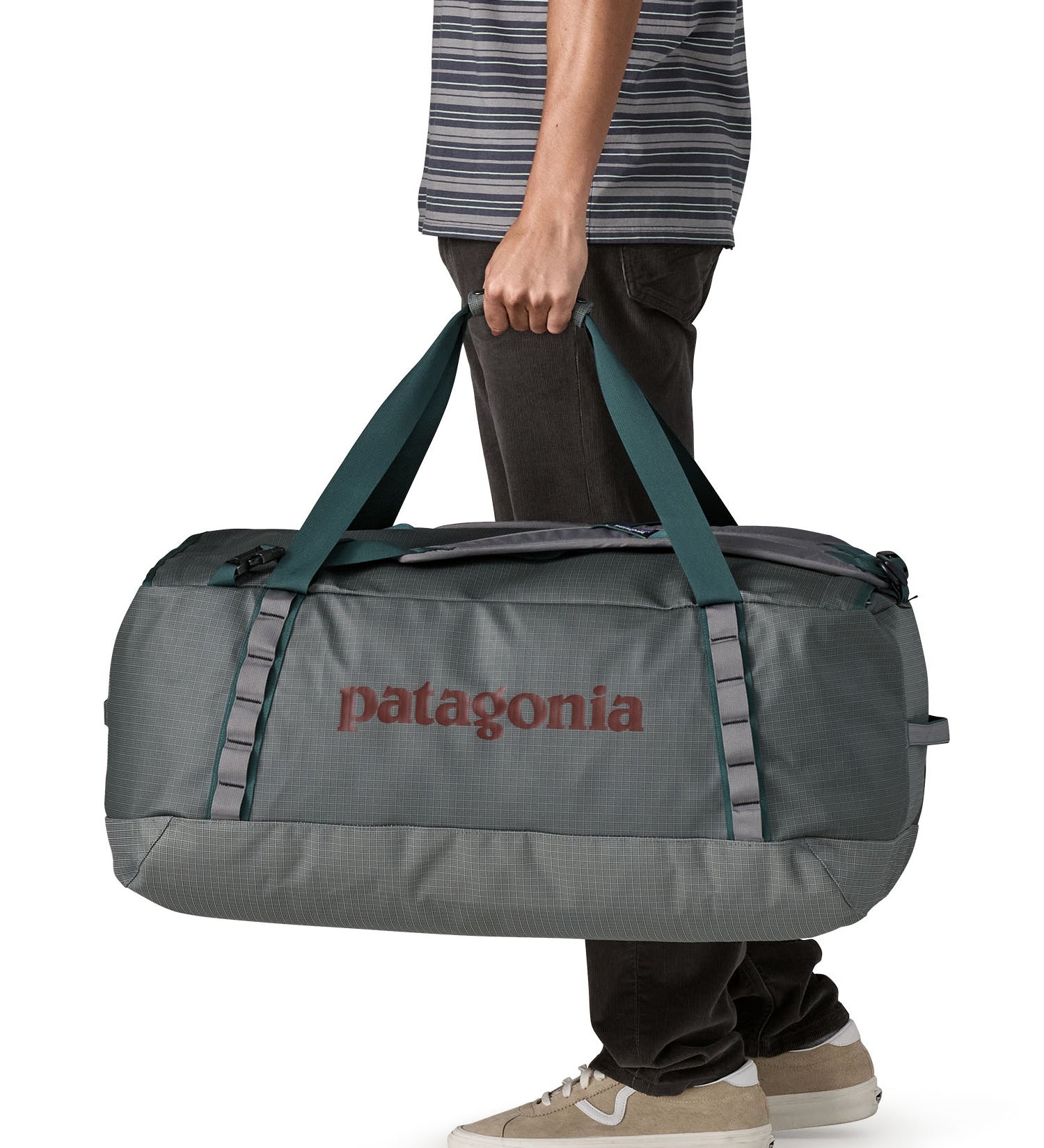 A man carrying the Patagonia black hole 70L duffel bag in noble grey available at Babipur. 