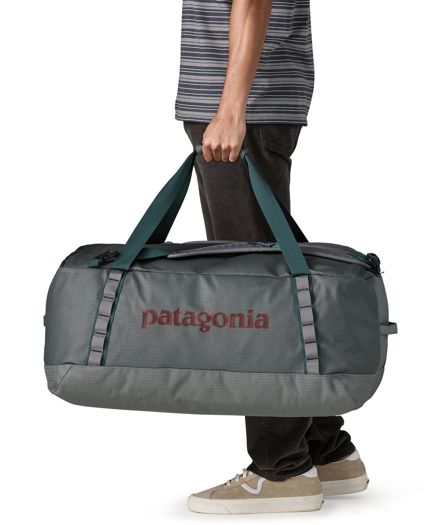 A man carrying the Patagonia black hole 70L duffel bag in noble grey available at Babipur. 