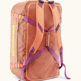 Patagonia black hole 70l duffel bag in bright orange with matching shoulder straps and extra purple carry handles