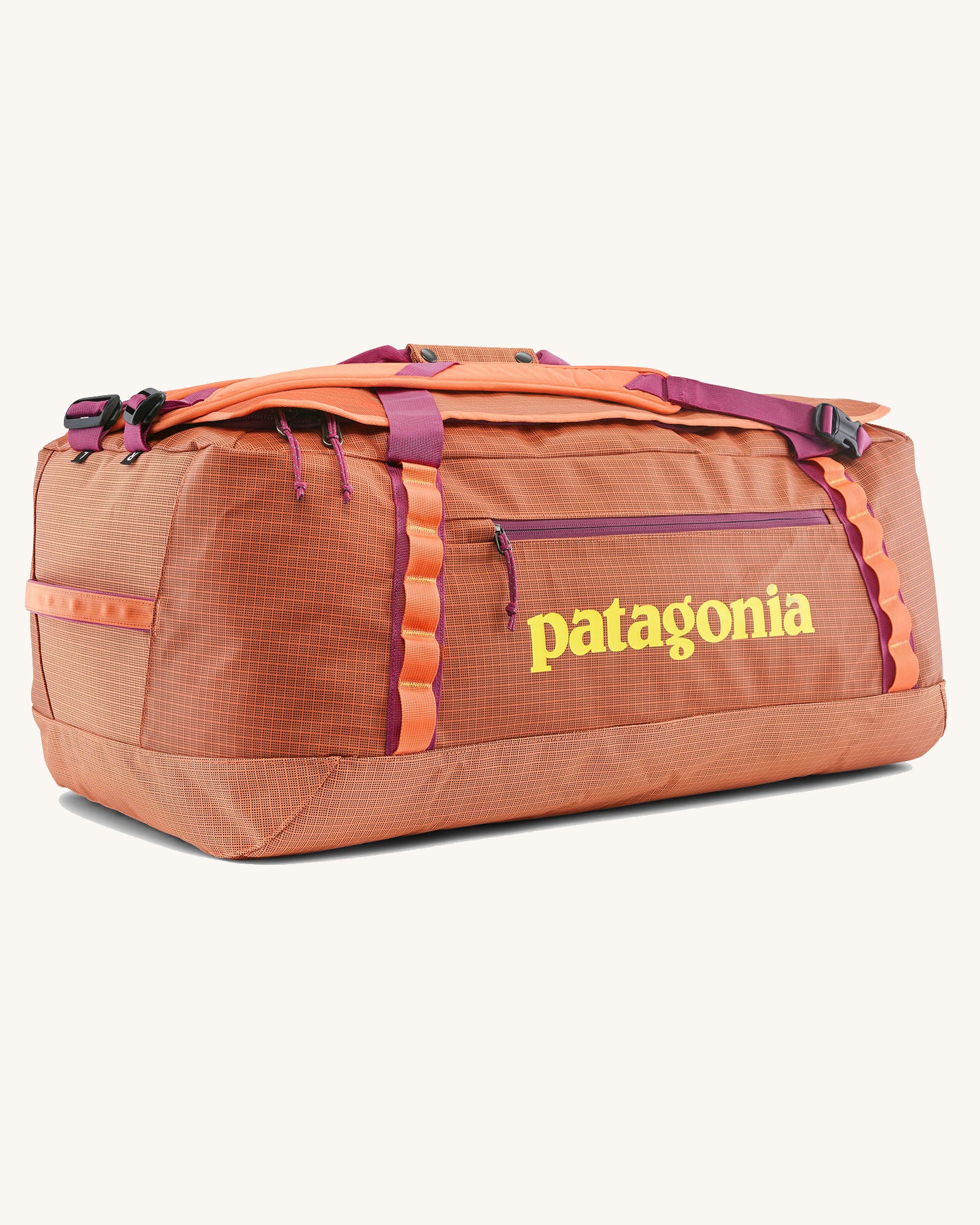 Patagonia black hole 70l duffel bag in bright orange with purple zip details, straps and yellow printed logo on front panel 
