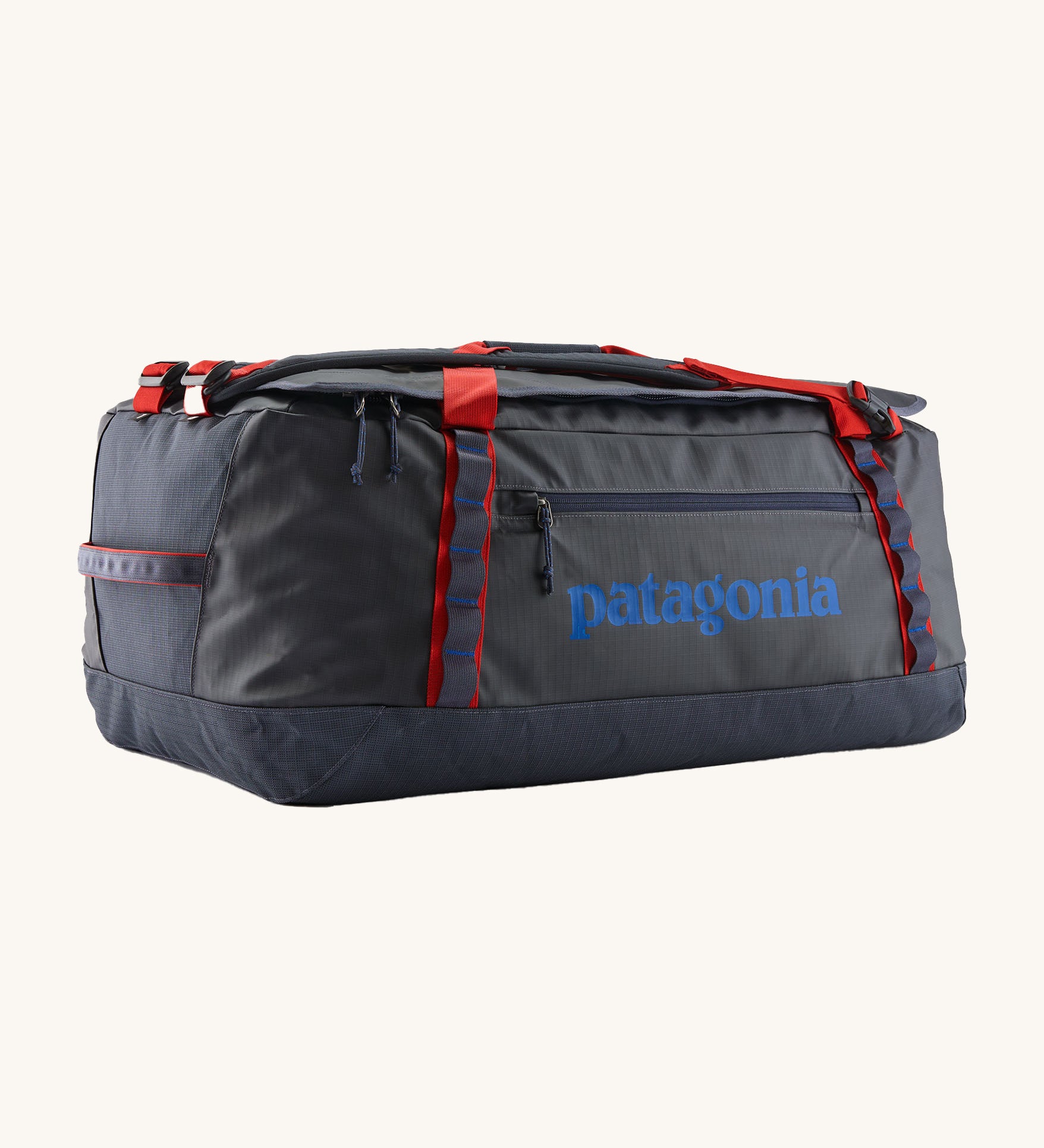 Patagonia black hole 70L duffel bag in smolder blue / amanita red available at Babipur. A dark blue bag with red trim and blue branding on the side. Features shoulders straps and a handle on the top for easy carrying.