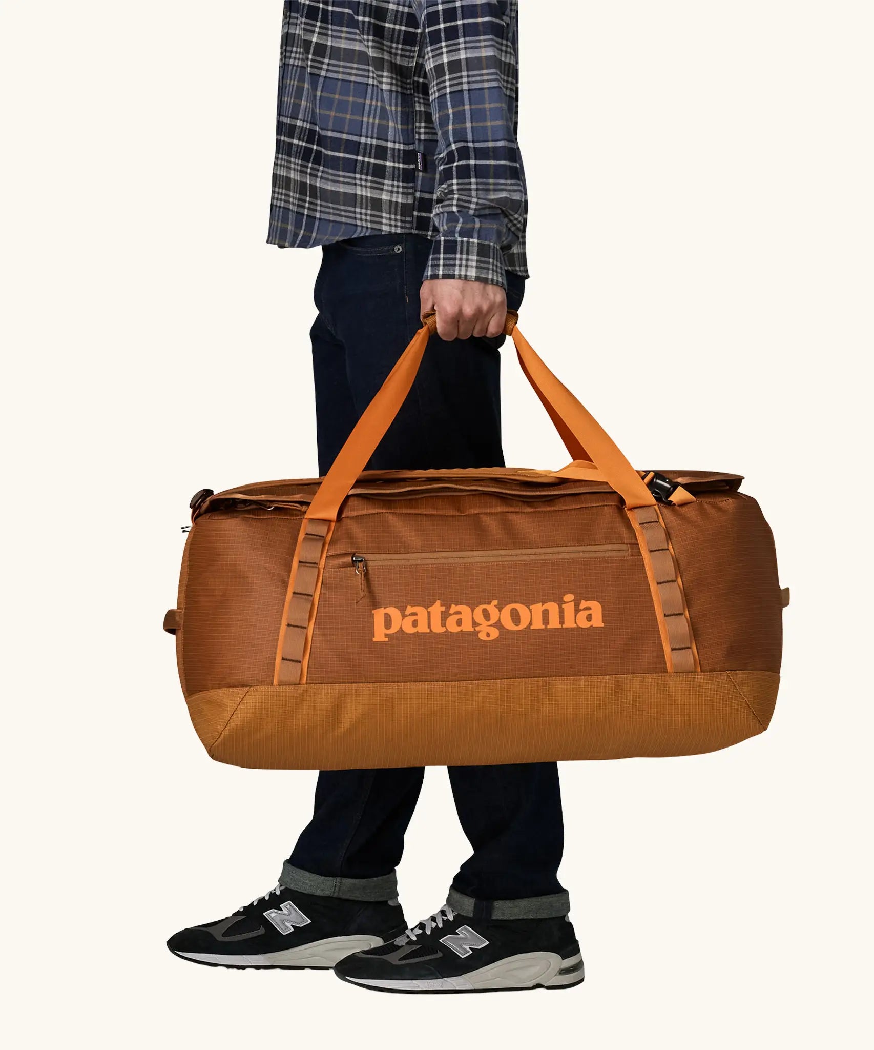 Patagonia Black Hole Duffel 70L in Cinnamon Brown. Bag being held by handle straps. 