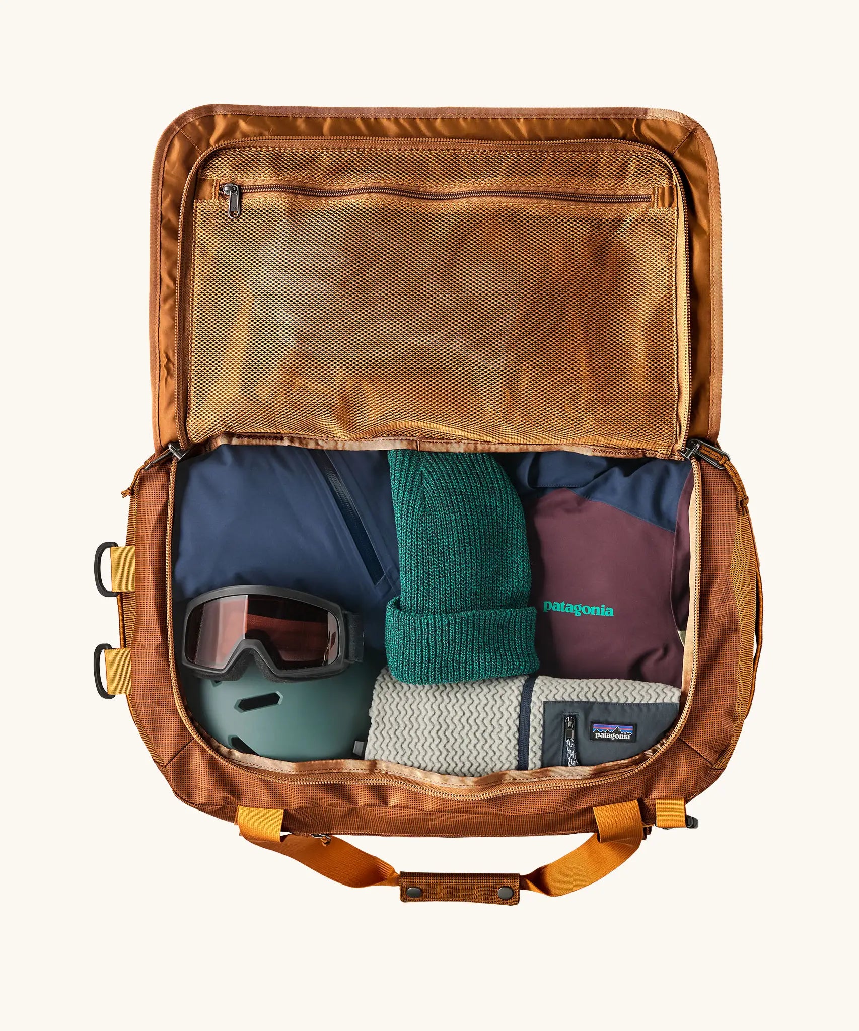 Patagonia Black Hole Duffle 70L in Cinnamon Brown, open showing storage space and mesh zipped pocket. 
