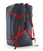 A close up of the Patagonia black hole 100L duffel bag in smolder blue / amanita red available at Babipur showing the shoulder straps and carry straps with red trim detail