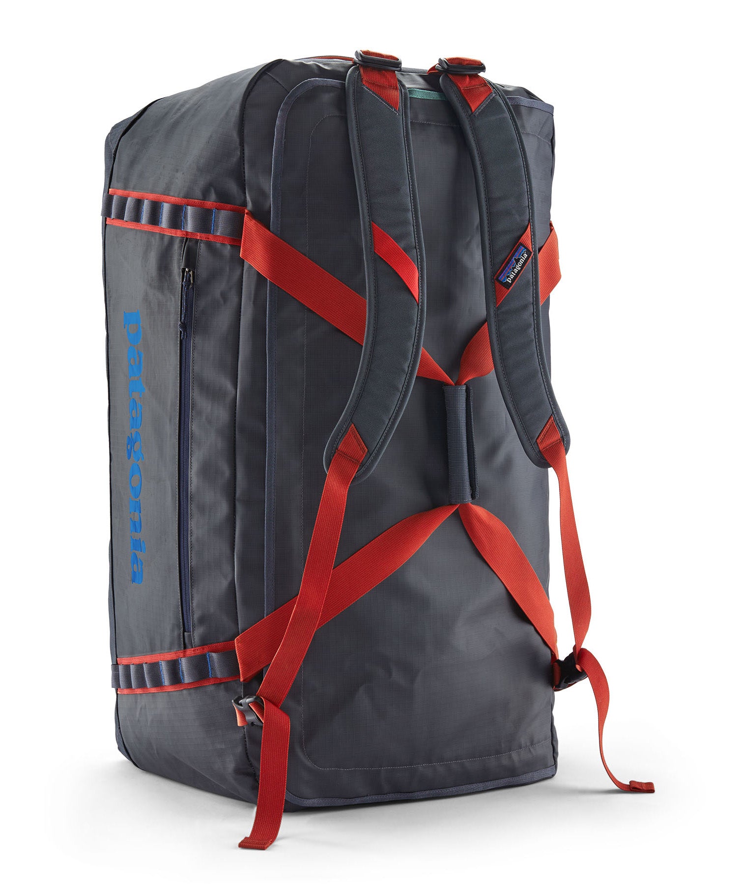 A close up of the Patagonia black hole 100L duffel bag in smolder blue / amanita red available at Babipur showing the shoulder straps and carry straps with red trim detail