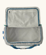An open Patagonia black hole 55l duffel bag in birch white showing zipped compartment on the inside of the lid