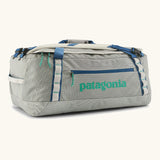 Patagonia black hole 55l duffel bag in birch white with blue zip details and mint green printed logo.