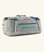 Patagonia black hole 55l duffel bag in birch white with blue zip details and mint green printed logo.