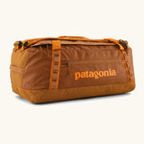 Patagonia black hole 55L duffel bag in Cinnamon Brown. Rusty brown/orange body, Features matching zip details, carry straps, extra carry loop and a printed logo on the side. 