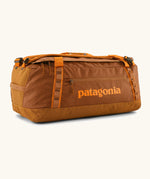 Patagonia black hole 55L duffel bag in Cinnamon Brown. Rusty brown/orange body, Features matching zip details, carry straps, extra carry loop and a printed logo on the side. 