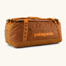 Patagonia black hole 55L duffel bag in Cinnamon Brown. Rusty brown/orange body, Features matching zip details, carry straps, extra carry loop and a printed logo on the side. 
