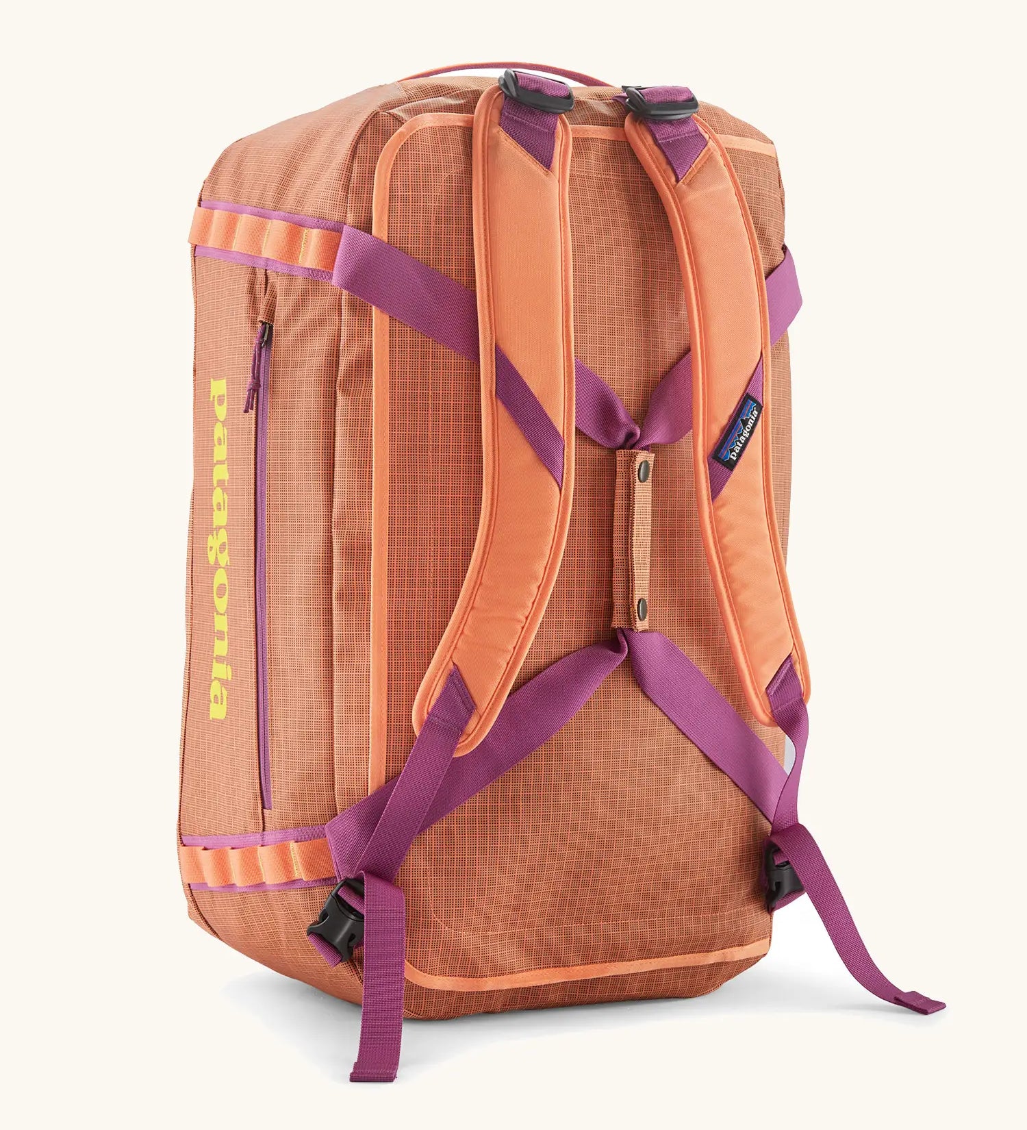 Back of Patagonia black hole 55l duffel bag in bright orange with matching shoulder straps and extra purple carry handles