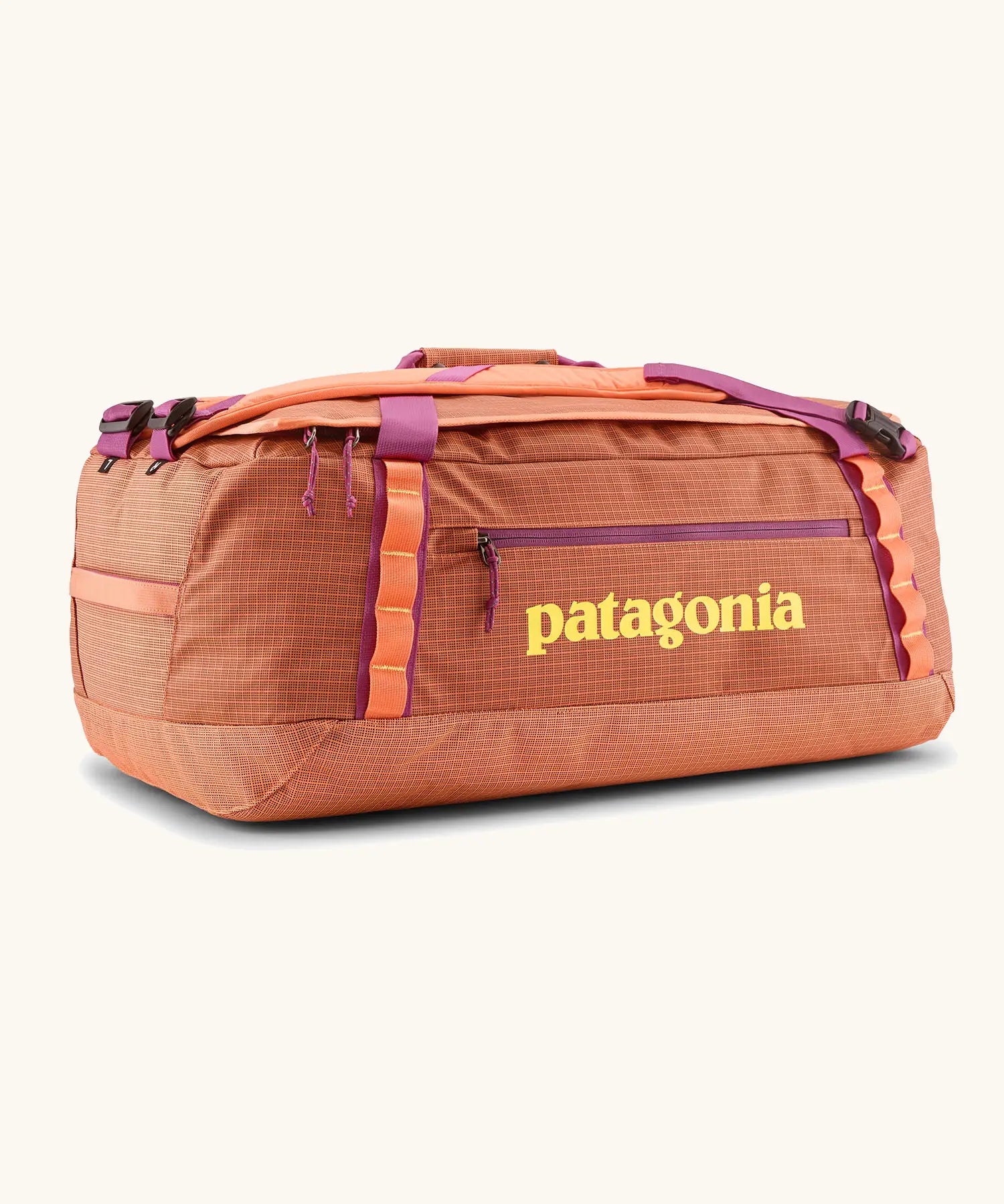Patagonia black hole 55l duffel bag in bright orange with purple zip details, straps and yellow printed logo on front panel 