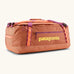 Patagonia black hole 55l duffel bag in bright orange with purple zip details, straps and yellow printed logo on front panel 
