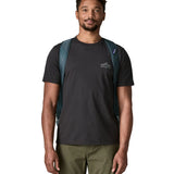 Front of man carrying the Patagonia black hole 55L duffel bag in dark teal using the padded shoulder straps