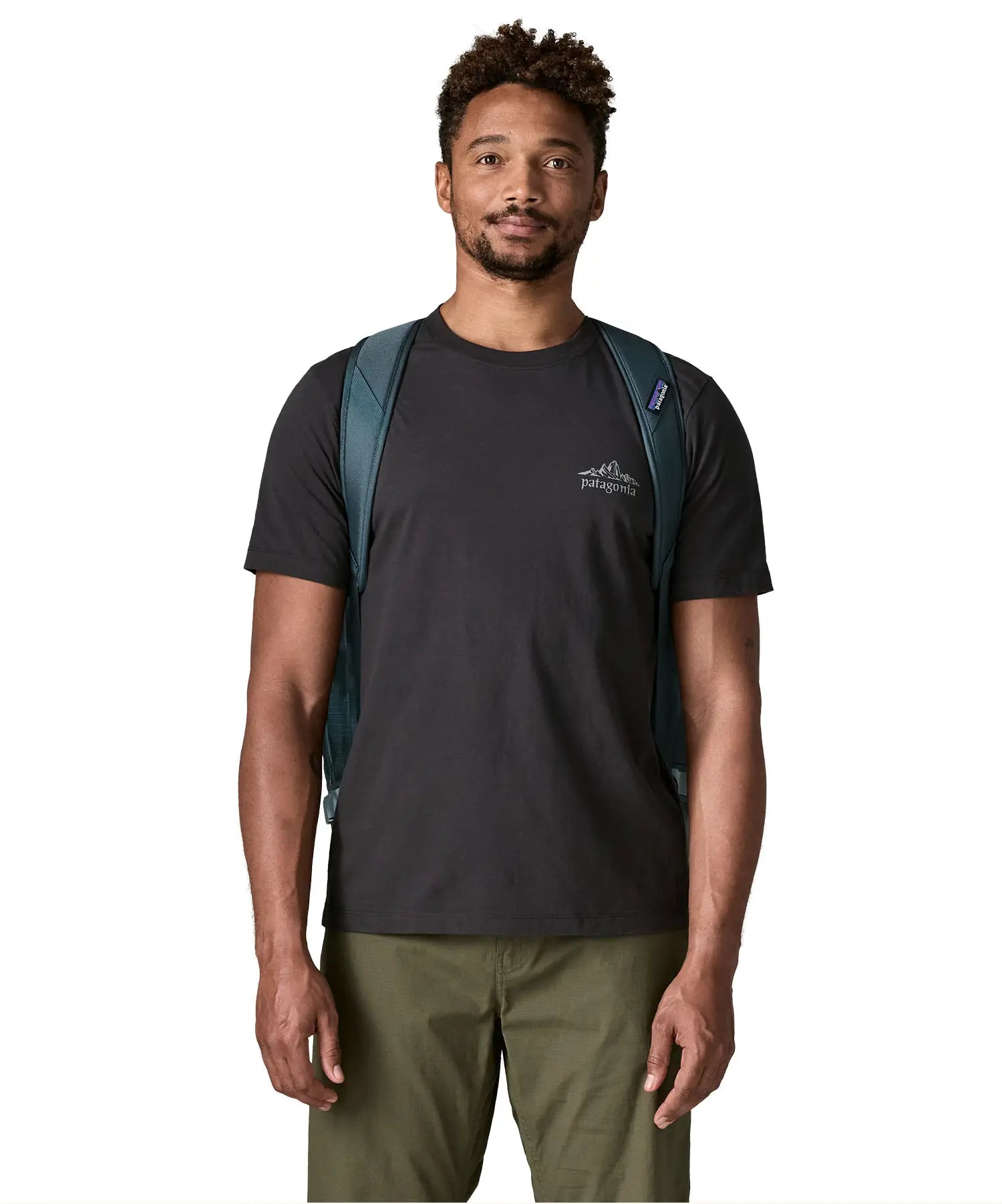 Front of man carrying the Patagonia black hole 55L duffel bag in dark teal using the padded shoulder straps