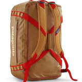 A close up of the Patagonia black hole 55L duffel bag in talon gold available at Babipur showing the shoulder straps and carry straps detail