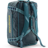 A close up of the Patagonia black hole 55L duffel bag in tidal teal / luminous pink available at Babipur showing the shoulder straps and carry straps detail