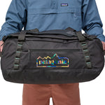 A person holding the Patagonia Black Hole Duffel 55L  Ink Black in their hands to show the size