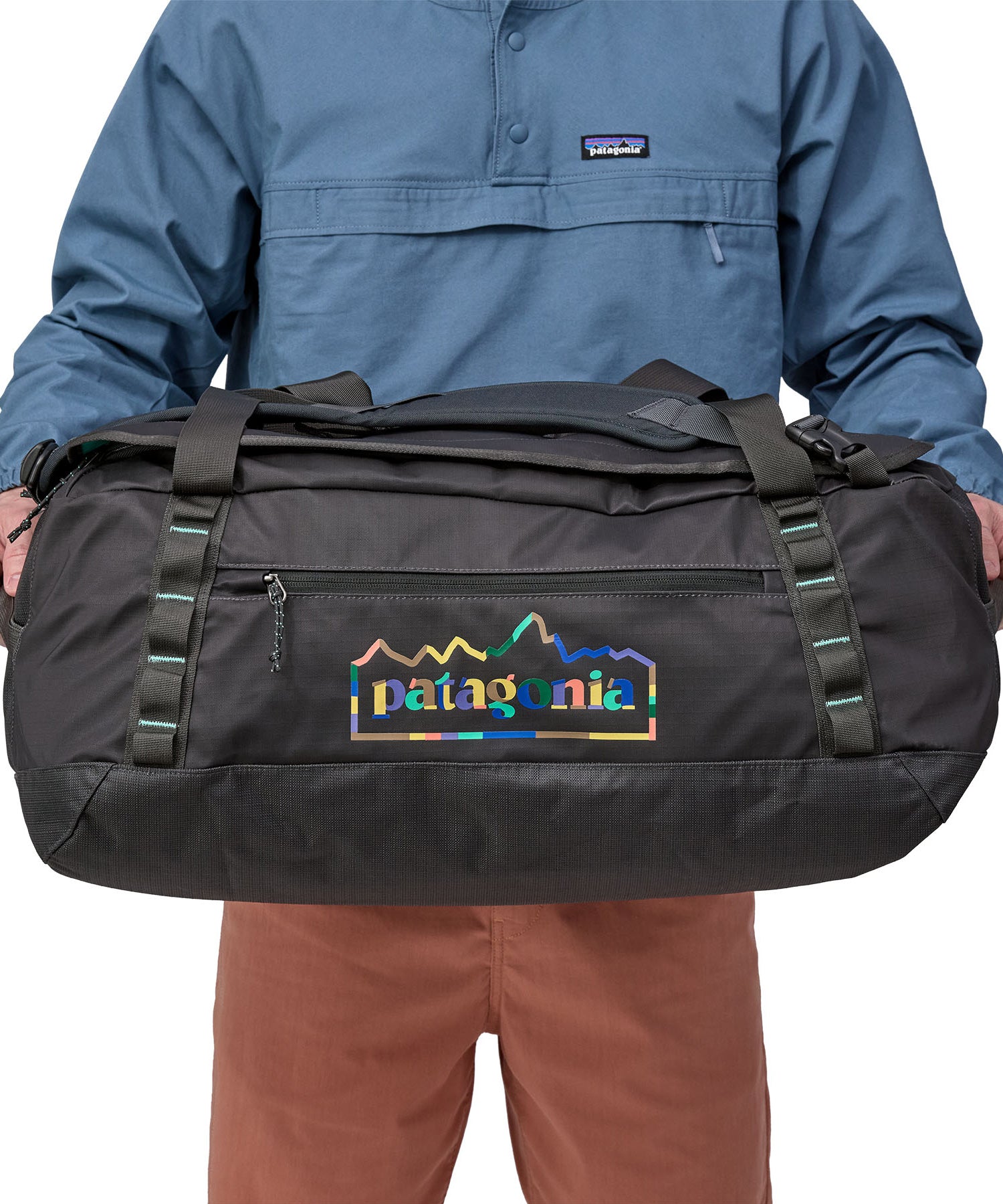 A person holding the Patagonia Black Hole Duffel 55L  Ink Black in their hands to show the size