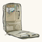 An open Patagonia 30 litre black hole weather resistant travel backpack beige showing items inside different compartments 