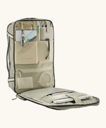 An open Patagonia 30 litre black hole weather resistant travel backpack beige showing items inside different compartments 