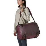 An adult carrying a Patagonia 45 litre black hole travel backpack in maroon over the shoulder 