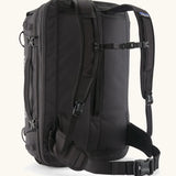 Back of Patagonia 45 litre black hole weather resistant travel backpack in all black showing padded shoulder and hip straps with buckle fasteners