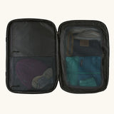 An open Patagonia 45 litre black hole weather resistant travel backpack in all black showing clothes inside different compartments 