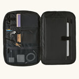 An open Patagonia 45 litre black hole weather resistant travel backpack in all black showing items inside different compartments 