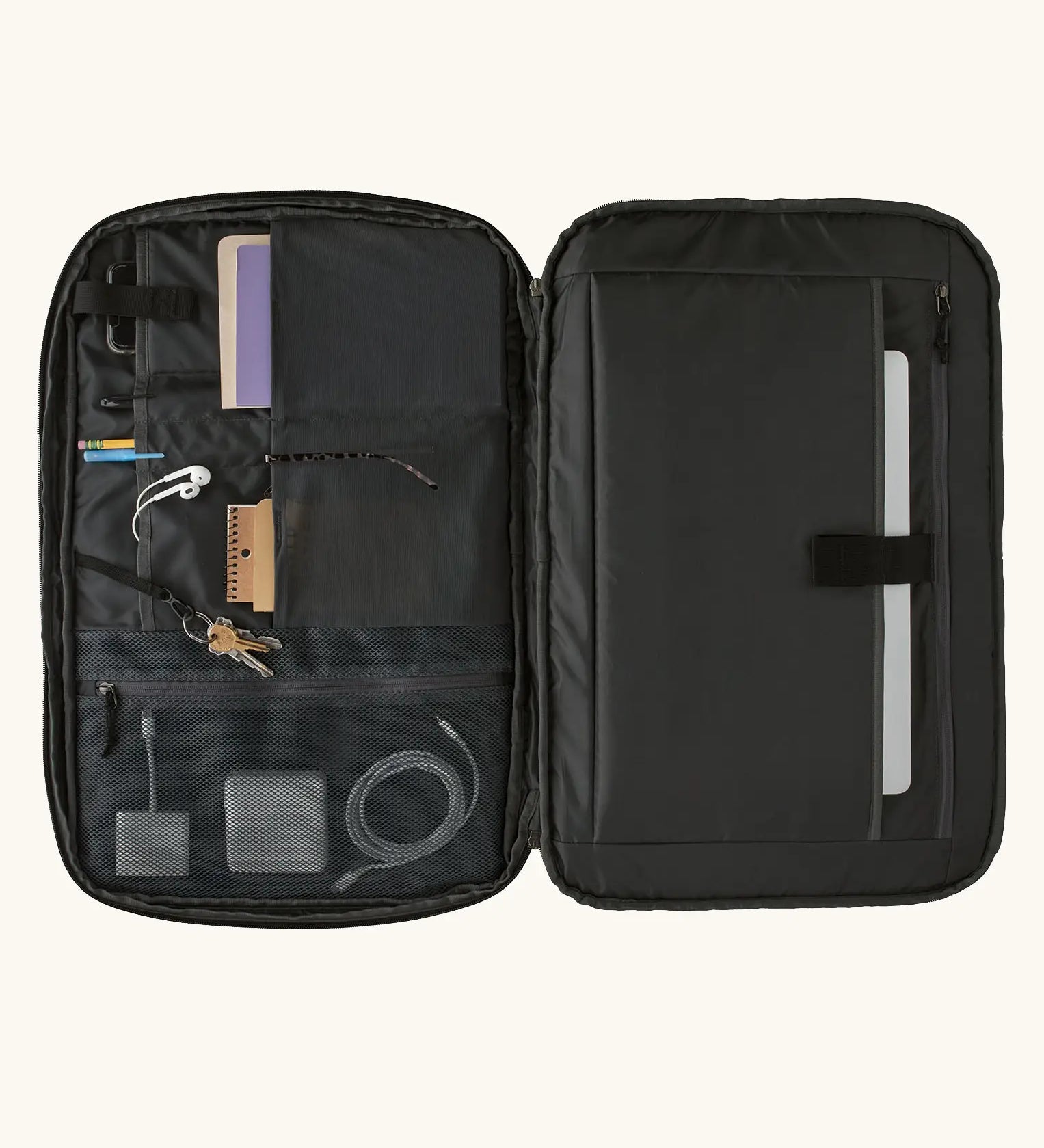An open Patagonia 45 litre black hole weather resistant travel backpack in all black showing items inside different compartments 