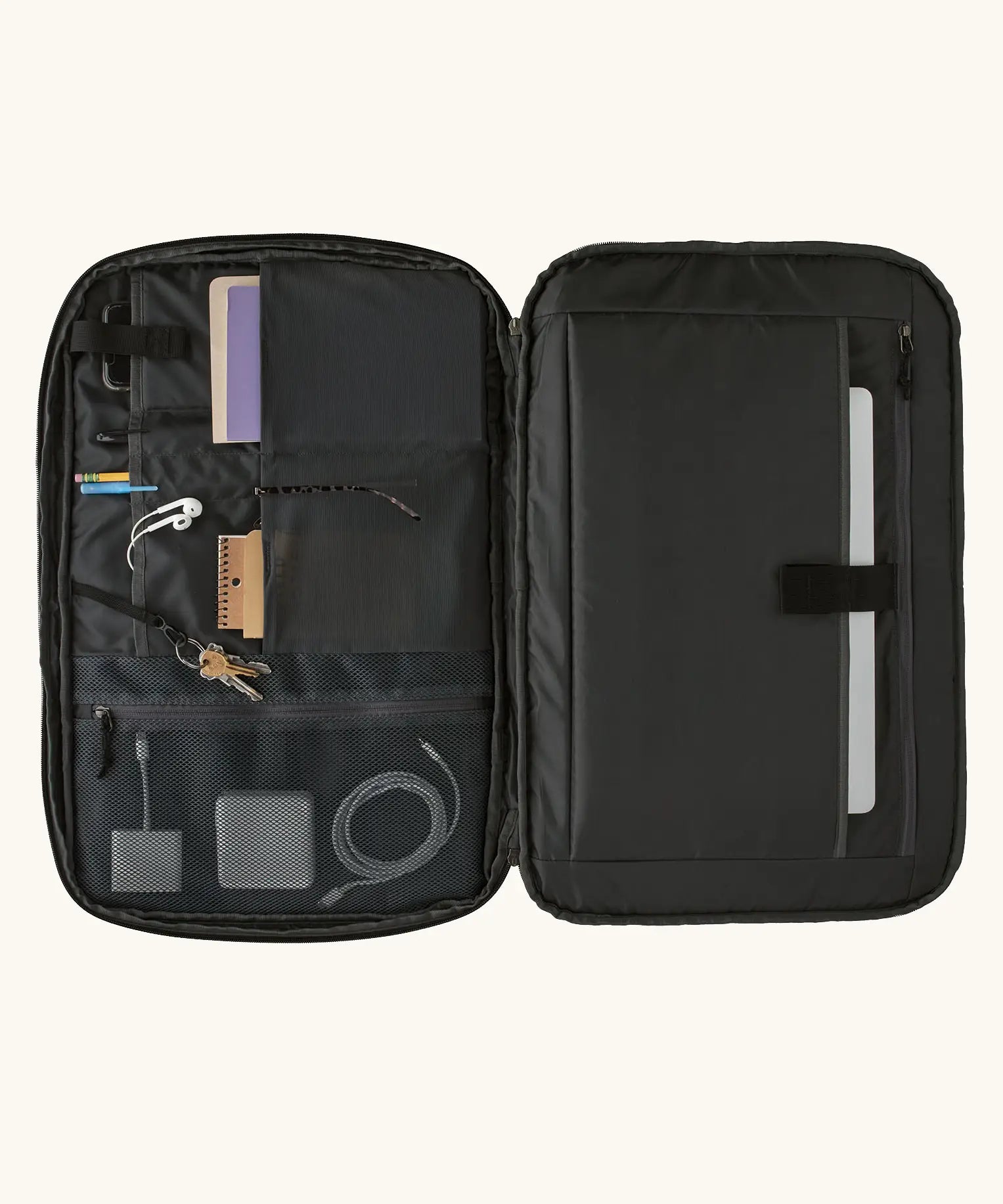 An open Patagonia 45 litre black hole weather resistant travel backpack in all black showing items inside different compartments 
