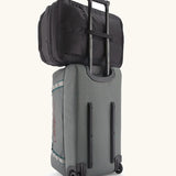 Patagonia 45 litre black hole weather resistant travel backpack in all black on top of a wheeled duffel bag through a loop on the back