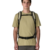 Front of adult carrying a Patagonia 45 litre black hole travel backpack in beige showing the shoulder and hip strap with buckle fasteners