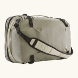 Patagonia 45 litre black hole weather resistant travel backpack in beige with black trim showing padded crossbody strap