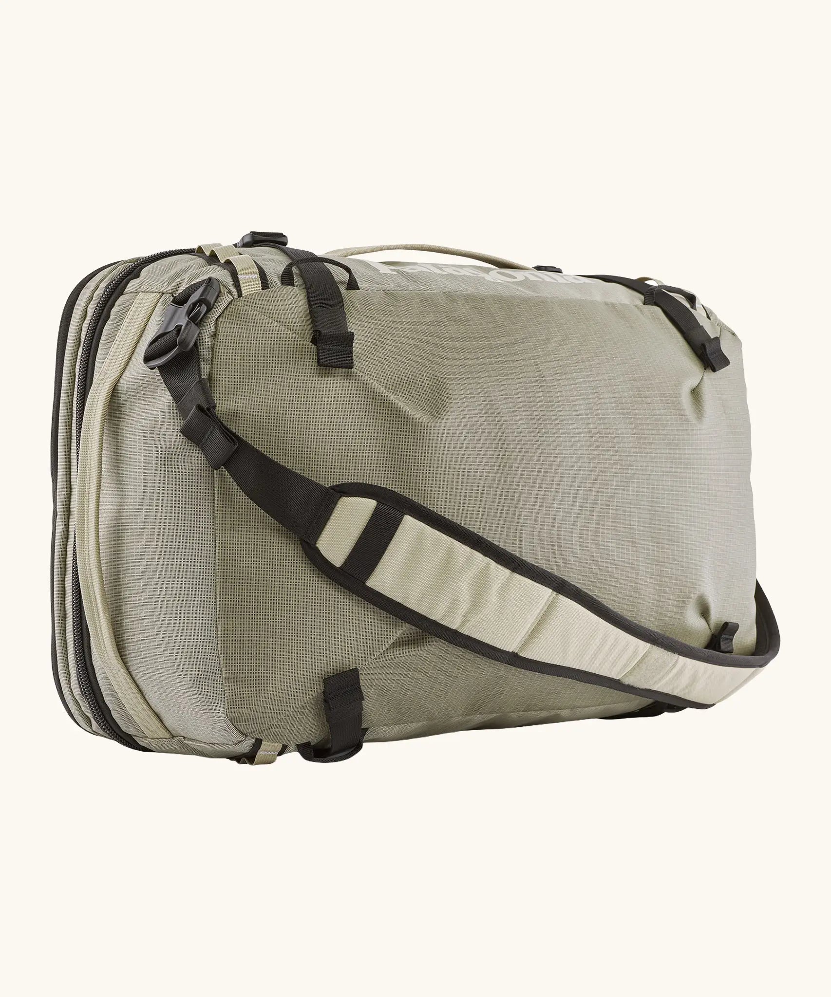 Patagonia 45 litre black hole weather resistant travel backpack in beige with black trim showing padded crossbody strap