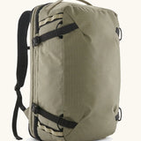 Patagonia 45 litre black hole weather resistant travel backpack in beige with black trim. Features padded shoulder pads, zipper fasteners and a carry handle