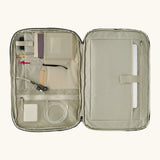 An open Patagonia 45 litre black hole weather resistant travel backpack beige showing items inside different compartments 