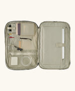 An open Patagonia 45 litre black hole weather resistant travel backpack beige showing items inside different compartments 