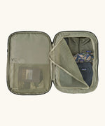 An open Patagonia 45 litre black hole weather resistant travel backpack in beige showing clothes inside different compartments 