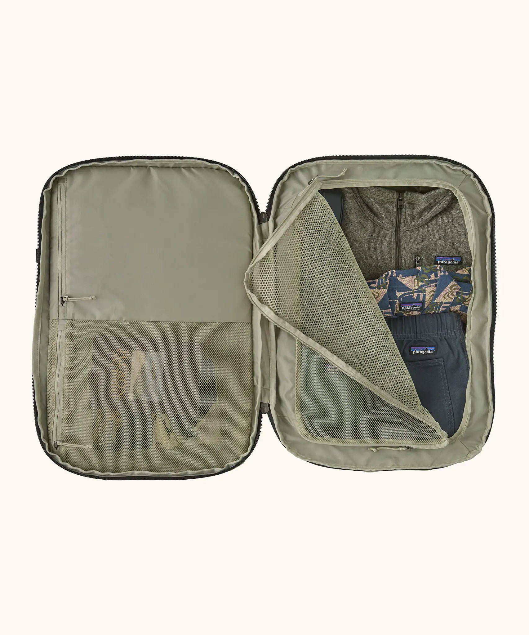 An open Patagonia 45 litre black hole weather resistant travel backpack in beige showing clothes inside different compartments 
