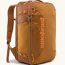 Patagonia 30 litre black hole weather resistant travel backpack in rust brown. Features padded shoulder pads, zipper fasteners and mesh side pocket
